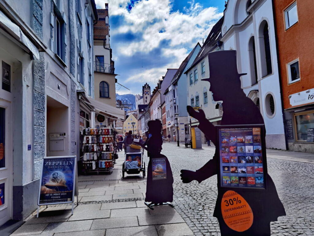 Füssen Sehenswürdigkeiten: Die Reichenstraße mit dem Hohen Schloss im Hintergrund